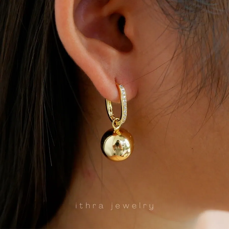 The Arabella gold hoop with a ball drop, worn