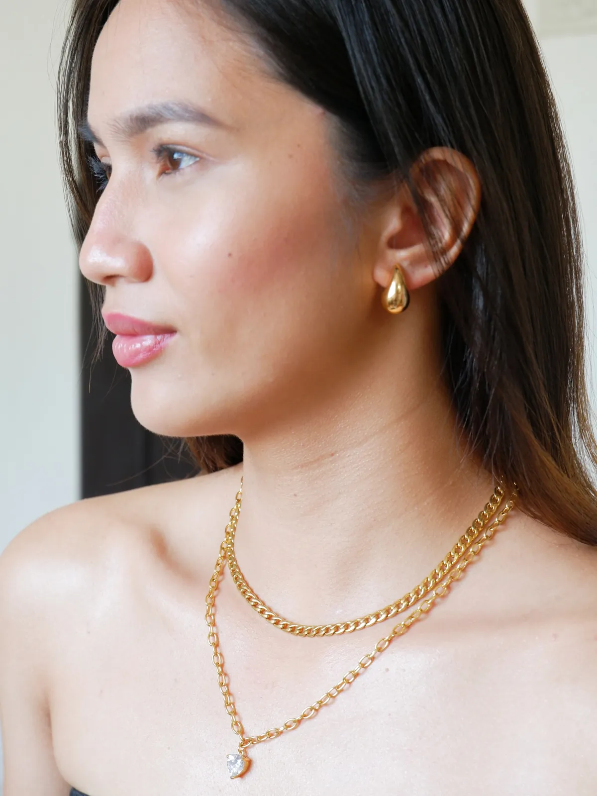 Layered gold chain necklaces with a heart pendant